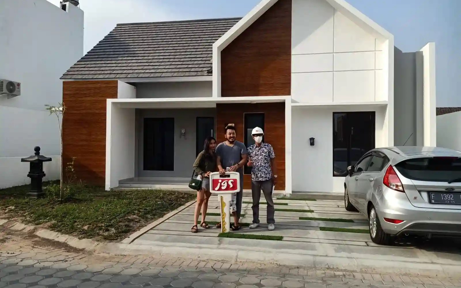Keluarga penghuni perumahan JGS di depan rumah mereka